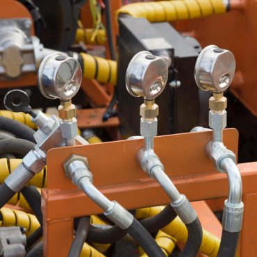 Hydraulic tubes, fittings and levers on control panel of lifting mechanism